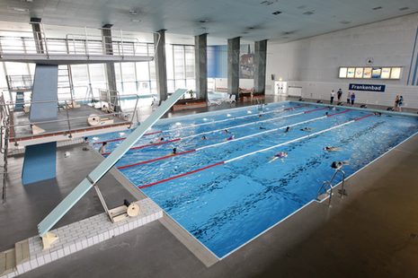 Die Innenaufnahme aus dem Frankenbad zeigt das Schwimmbecken und die Sprunganlage