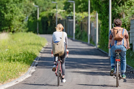 Zwei Radfahrende auf einem Radweg durch die Felder zwischen Bornheim und Bonn