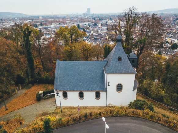 Luftbild der Michaelskapelle am Burgfriedhof mit der Stadt Bonn im Hintergrund.
