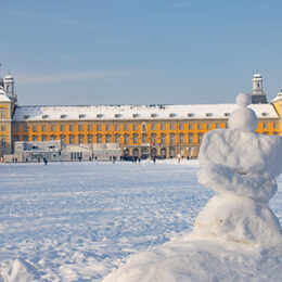 Der schneebedeckte Hofgarten und das Hauptgebäude der Universität