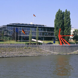 Der Plenarsaal vom Rhein aus gesehen mit der roten Skulptur L´Allumée am Rheinufer