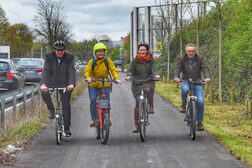 Die Festgäste fahren mit ihren Rädern auf dem neuen Radweg von Sankt Augustin kommend in Richtung Bonn.