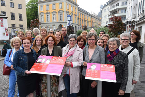 Das Bild zeigt Oberbürgermeisterin Katja Dörner mit den Gästen bei der Einweihung der Frauenorte, hier die zwei Stelen am Bischofsplatz für die "Stillen Heldinnen" und Johanna Elberskirchen.