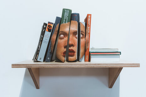 Buchrücken auf einem Regal ergeben ein zerteiltes menschliches Gesicht