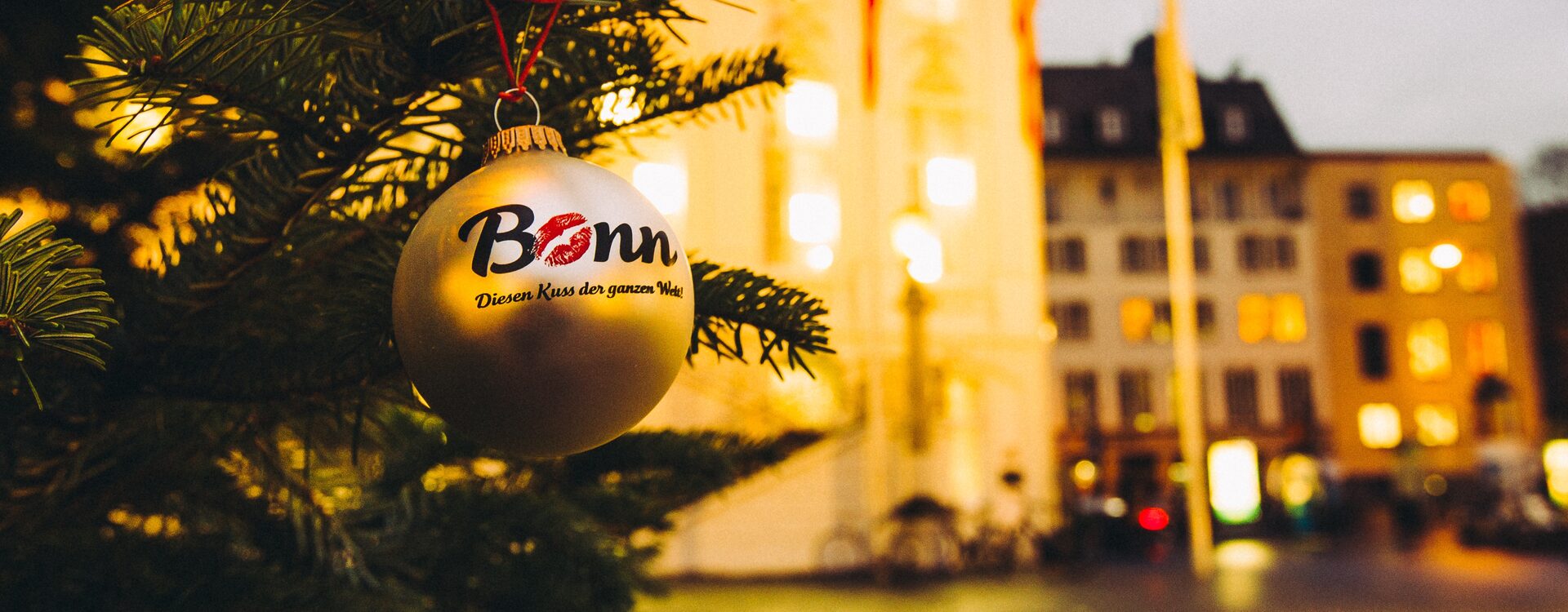 Weihnachtskugel mit dem Kussmund an einem Baum vor dem Alten Rathaus