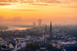 Sonnenaufgang über der Stadt Bonn. im Hintergrund die Skyline mit Post Tower und UN-Tower.