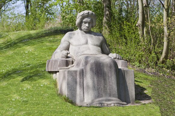 Sitzende Betonskulptur Ludwig van Beethovens in der Rheinaue