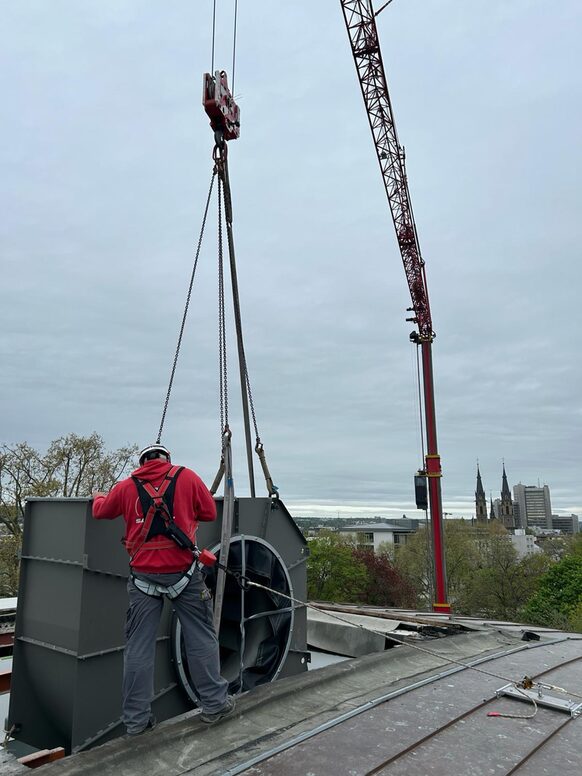 Mit einem Kran werden schwere Geräte über das Dach in die Beethovenhalle gehoben
