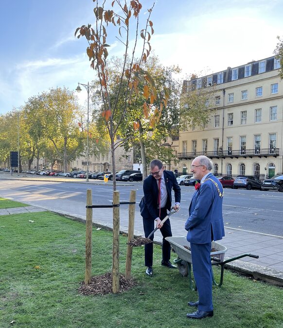 Bezirksbürgermeister Reeh-Schall pflanzt gemeinsam mit seinem Oxforder Amtskollegen, Lord Mayor James Fry, einen Kirschbaum unmittelbar vor der Gedenkstätte St. Giles.