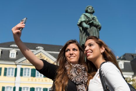 Zwei Frauen nehmen vor dem Beethovendenkmal ein Selfie auf