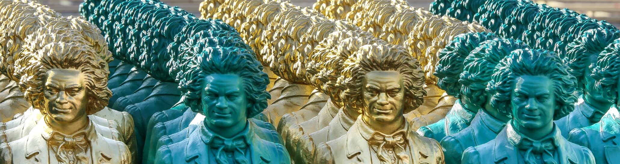 Viele Beethovenfiguren stehen in einer Reihe vor dem Aufbau auf dem Münsterplatz.