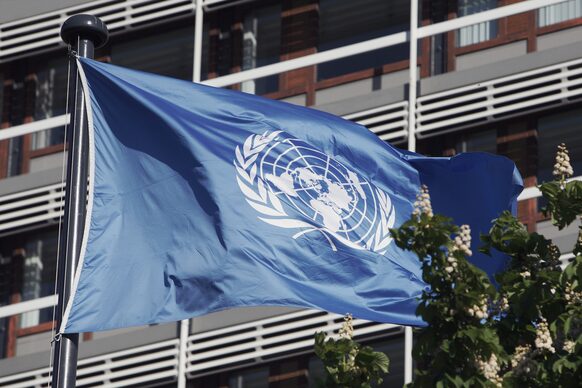 Die blaue UNO-Flagge flattert vom dem Hochhaus UN Campus
