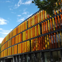 Die mit rot, gelb und grünen Lamellen bestückte Fassade des DZNE-Gebäudes in Bonn
