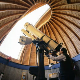 Ein Mann schaut durch ein Teleskop