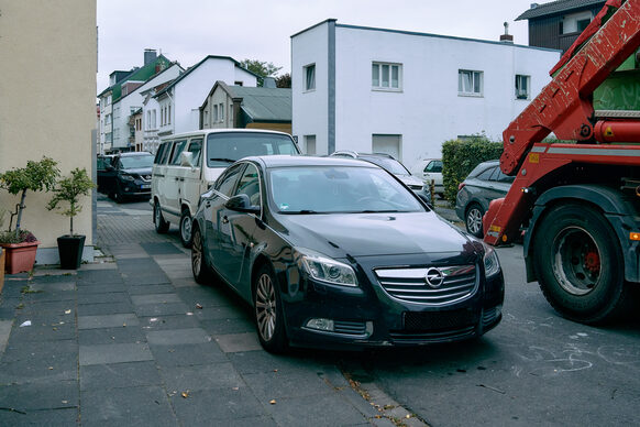 Das Bild zeigt die Kessenicher Straße in Dottendorf im Alltag mit vielen parkenden Autos.