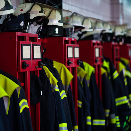 Die Uniformen von Feuerwehrleuten hängen im Umkleideraum