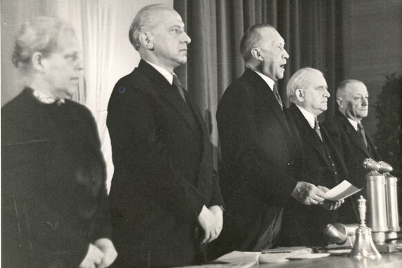 Konrad Adenauer, Präsident des Parlamentarischen Rates (M.), verkündet das Grundgesetz (v.l.: Helene Weber; Hermann Schäfer; Konrad Adenauer, Adolf Schönfelder; Jean Stock)