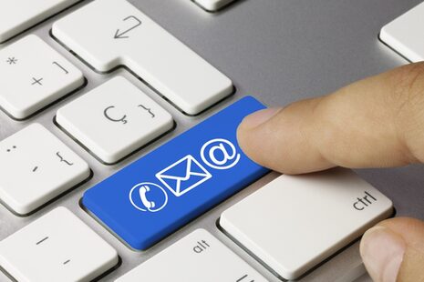 Die Entertaste an einer PC-Tastatur ist mit blau unterlegten Symbolen für E-Mail beschriftet