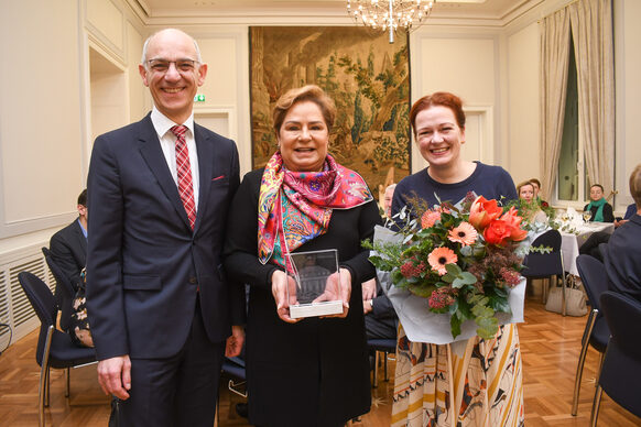 Mayor Katja Dörner and Volker Schramm, Chairman of the Association present the new "Döppekooche Queen" Patricia Espinosa with a glass trophy in the shape of the Old Town Hall.