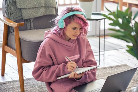 Eine junge Frau lernt vor dem Laptop