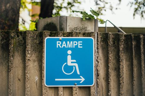 Blaues Hinweisschild auf eine Rampe für Rollstuhlfahrende