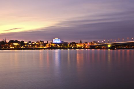 Der Rhein mit der beleuchteten Kennedybrücke und der Oper im Hintergrund