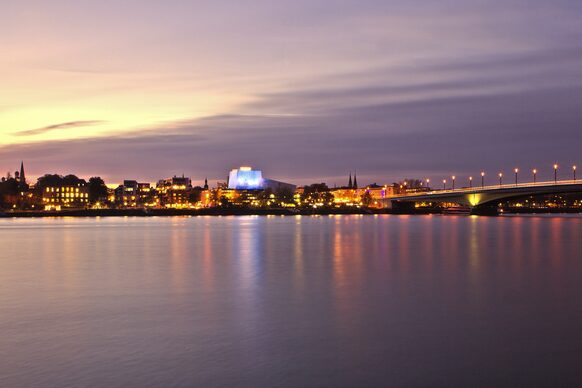 Der Rhein mit der beleuchteten Kennedybrücke und der Oper im Hintergrund