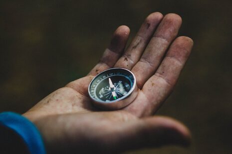 Ein Kompass liegt auf einer Hand.