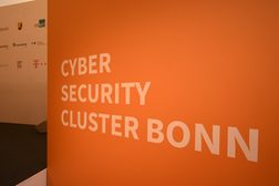 Ein orangefarbenes Schild mit der Aufschrift Cyber Security Cluster