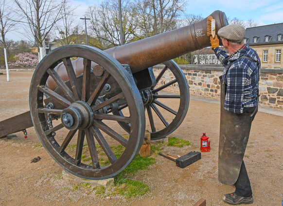 Stellmacher Walter Keil entfernt Graffitis an einer der beiden Kanonen.