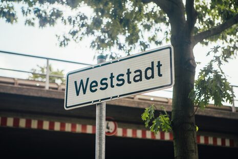 Ein weißes Ortsschild mit dem Schriftzug Weststadt