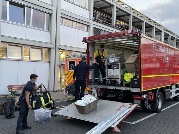 Mitglieder der Feuerwehr Bonn beim Beladen eines Einsatzfahrzeugs