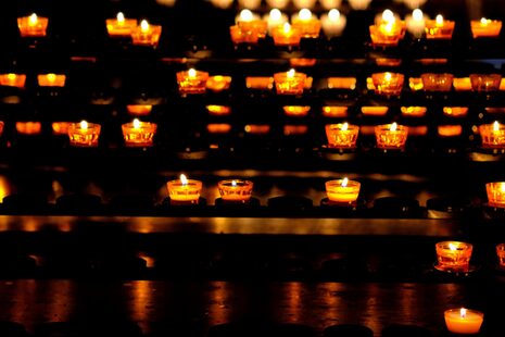 Ein Kerzenständer in einer Kirche mit vielen Teelichtern