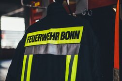 Einsatzjacke der Feuerwehr Bonn hängt an einem Kleiderhaken.