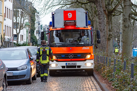 Feuerwehrauto fährt die schmale Poppelsdorfer Allee entlang und hat durch geparkte Pkw kaum Platz zum Durchkommen.