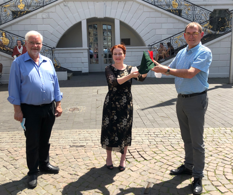 Caritasdirektor Jean-Pierre Schneider (r.) und Diakonie-Geschäftsführer Ulrich Hamacher überreichen OB Katja Dörner als Schirmherrin den „Robin-Good-Hut“.