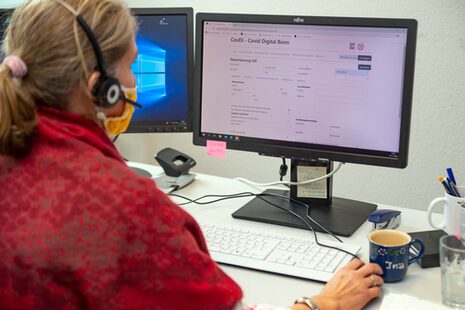 Eine Frau sitzt an einem Computer im Gesundheitsamt.