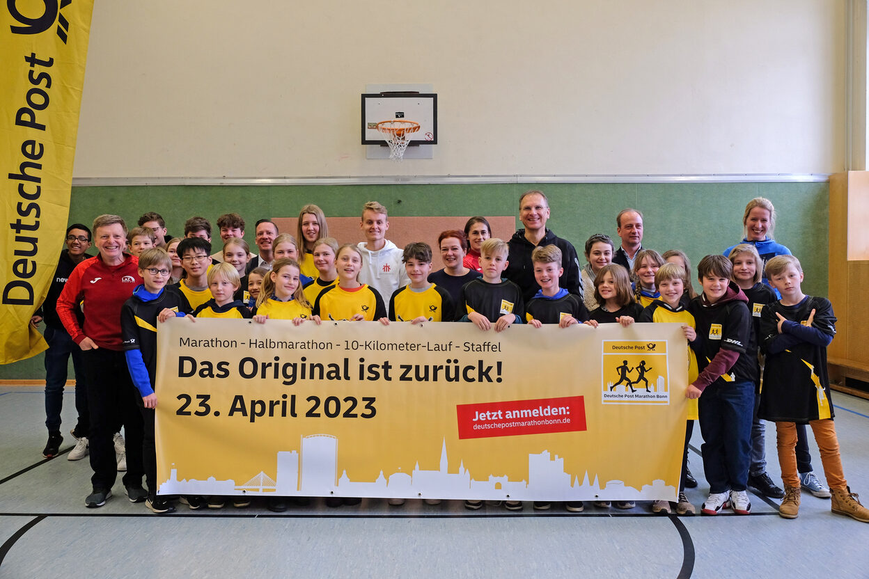 Beteiligte des Deutsche-Post-Marathons Bonn, Oberbürgermeisterin Katja Dörner in der Mitte, mit Schüler*innen des Clara-Schumann-Gymnasiums.