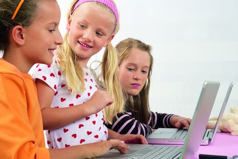 Drei Mädchen arbeiten an Laptops
