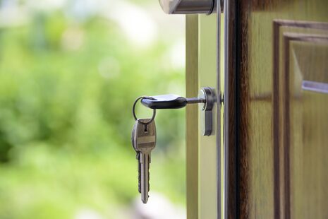 Ein Schlüssel aus einem Schlüsselbund steckt in einer Haustür