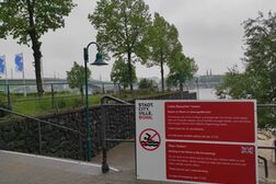 Warnschild "Schwimmen im Rhein ist lebensgefährlich!" am Rheinufer.