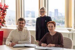 An einem Tisch sitzend unterzeichnen Steven Walter und Oberbürgermeisterin Katja Dörner die Vertragsverlängerung, dahinter stehend Kulturdezernentin Dr. Birgit Schneider-Bönninger.