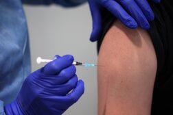 Eine Person mit entblößtem Oberarm wird mit dem Coronaimpfstoff geimpft