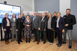 Das Bild zeigt Oberbürgermeisterin Katja Dörner (im Kleid) mit NRW-Arbeitsminister Karl Josef Laumann sowie die Organisator*innen und Teilnehmende des Fachdialogs, organisiert von der Regionalagentur Bonn/Rhein-Sieg.