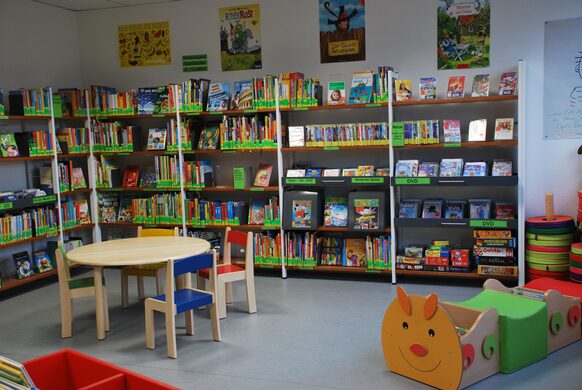 Regale mit Büchern, CDs, DVDs und Konsolenspielen für Kinder und Jugendliche in der integrierten Stadtteilbibliothek Auerberg