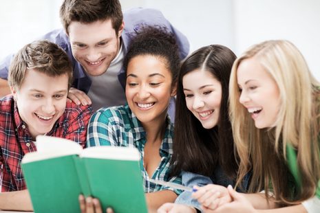 Fünf junge Erwachsene schauen gemeinsam in ein Buch