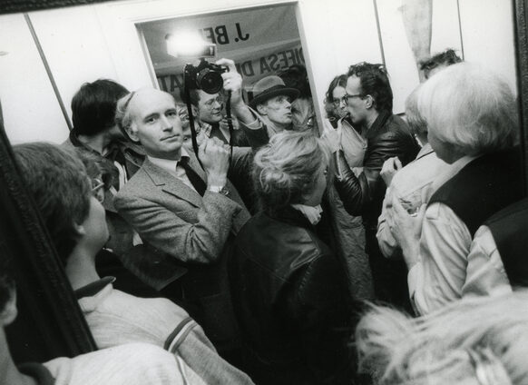 Franz Fischer, umringt von einer kleinen Menschentraube, fotografiert sich in einem Spiegel