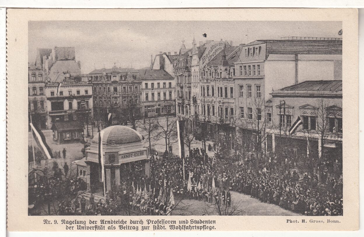 Das Bild ist eine alte Postkarte von 1917, die viele Menschen auf dem Münsterplatz zeigt.