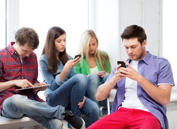 Jugendliche mit Handy und Tablet