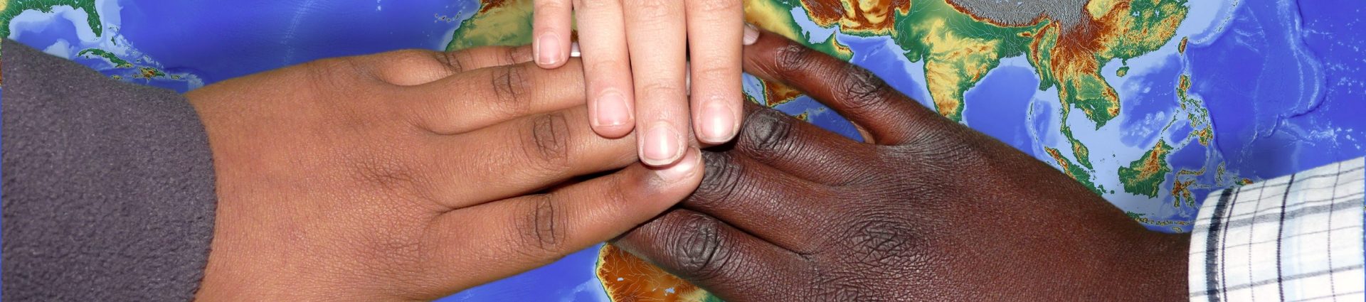 Drei Personen unterschiedlicher Hautfarbe halten gemeinsam eine Weltkugel in den Händen